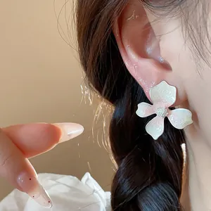 Close-up detail of a sweet floral stud earring with glittery pink gradient petals worn on ear