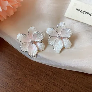 Vue détaillée des boucles d'oreilles fleur en zircon rose avec texture scintillante.