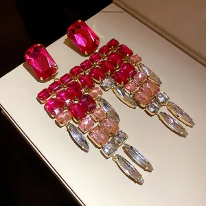 Detailed view of oversized pink and clear crystal chandelier earrings in gold setting.