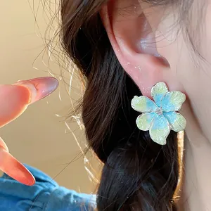 Gros plan de boucles d'oreilles fleurs en émail dégradé avec zircon