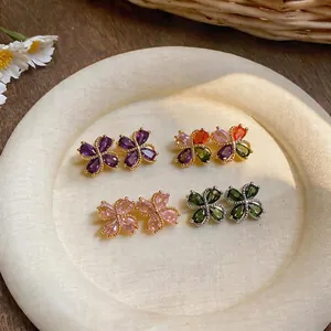 Elegante bunte Zirkon Blumen-Ohrstecker für Damen auf einem strukturierten Teller.