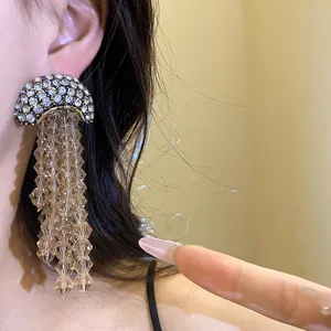 Detail showing champagne crystal beaded tassels and rhinestone crescent on elegant earring
