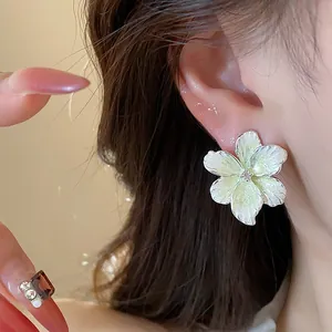 Gros plan d'une élégante boucle d'oreille fleurie avec zircon sur une oreille de femme