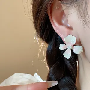 Elegant white flower stud earrings with subtle pink gradient and sparkling glitter