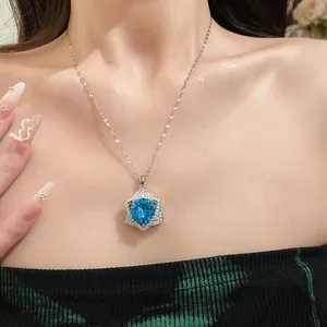 Detailed view of a silver necklace with a heart-shaped blue gemstone in a star pendant.