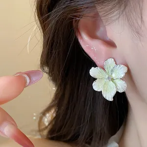 Vue rapprochée de puces d'oreilles fleur argent avec émail vert clair et zircon