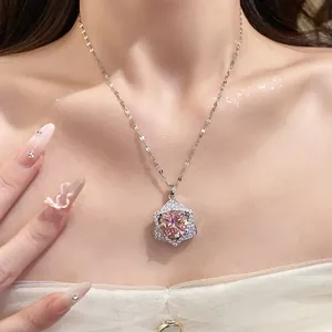 Elegant star pendant necklace with pink gemstone shown on a woman's neck in close-up detail
