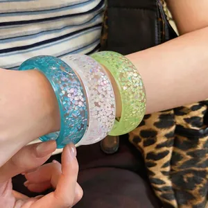 Vibrant set of colorful dopamine style resin bangles with iridescent flakes shown on arm