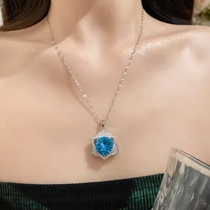 Macro view of a silver necklace with a star-shaped blue pendant worn on the neck