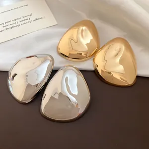 Detailansicht metallischer geometrischer Ohrstecker in Gold und Silber mit Hochglanz.