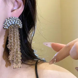 Close-up of elegant crystal tassel earrings with sparkling rhinestone studs