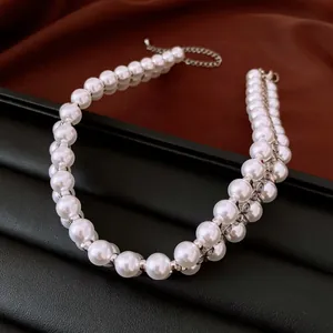 Detailansicht einer eleganten Perlenkette mit funkelnden Abstandshaltern aus Strass.