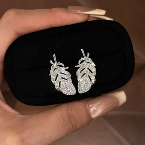 Detail of silver feather stud earrings with sparkling rhinestones in a display box