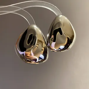 Elegante Nahaufnahme von glänzenden silbernen Tropfenohrsteckern mit glattem Metall.