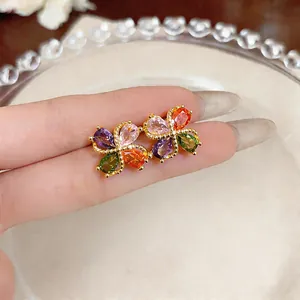 Detailaufnahme eleganter goldener Blumenohrstecker mit lebhaften bunten Zirkoniasteinen