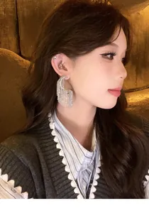Elegant silver geometric tassel earring worn by a model in warm indoor lighting