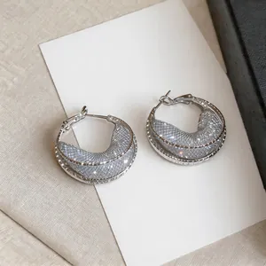 Detailed macro view of elegant silver-toned hoop earrings with a crystal mesh hollow design