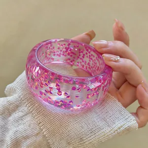 Close-up of a pink resin circular bangle with sparkling magenta geometric inclusions