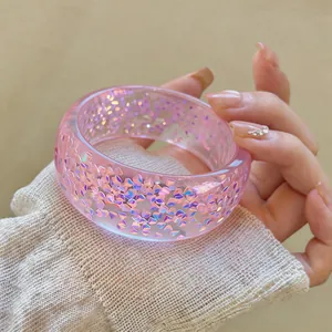 Detailed macro view of pink resin bracelet with shimmering iridescent glitter flakes inside