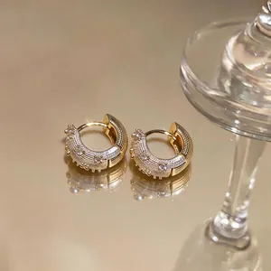 Elegant gold hoop earrings featuring white enamel inlay and sparkling zircon stone accents