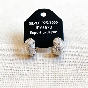 Silver-tone textured hoop earrings with zircons displayed on a black jewelry card