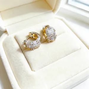 Detailed macro view of gold and silver textured hoop earrings with inlaid zircons