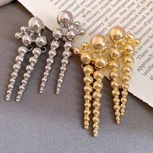 Detail of vintage metallic bead drop earrings in shiny gold and silver finishes