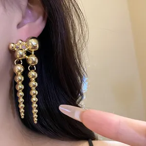 Close-up of vintage gold spherical drop earrings for a minimalist luxury style