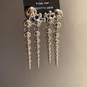 Close-up of silver beaded fringe dangle earrings featuring a vintage minimalist design
