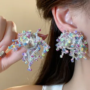 Close-up detail of irregular silver earrings with vibrant colorful sequins and glass beads