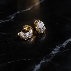 Close-up view of elegant French-style zircon hoop earrings on a black marble surface