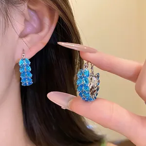 Vintage blue marquise zircon wheat ear hoop earrings shown on ear and held by model