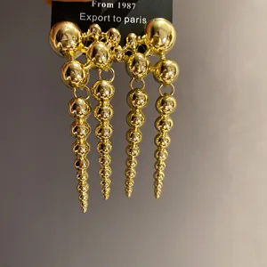 Detailed view of vintage golden earrings featuring tiered strands of metallic beads.