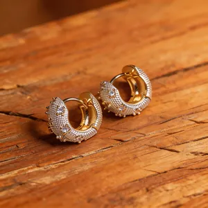Macro detail of French style zircon hoop earrings with textured gold and silver finish