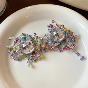 Detailed view of irregular silver ball earrings with vibrant multicolored sequins