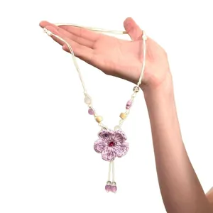 Collana con fiore all'uncinetto viola e perline di legno e ceramica da donna