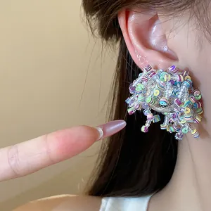 Close-up detail showing vibrant colorful sequin and glass bead stud earrings on a model ear