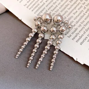 Detailed view of vintage silver cascading ball drop earrings on book page background