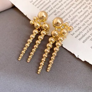 Macro view of vintage golden beaded cluster drop earrings with silver needle post details