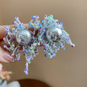 Detail of handmade multi-color sequin and glass bead irregular earrings with silver spheres