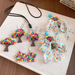 Détail de bijoux ethniques en perles de bois avec boucles d'oreilles arbre et étoile.