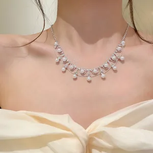 Close-up view of an elegant French vintage pearl and rhinestone fringe necklace on model