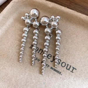 Macro view of silver cascading bead earrings with a highly polished metallic finish.