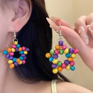 Gros plan de boucles d'oreilles étoile en perles de bois colorées, style ethnique.