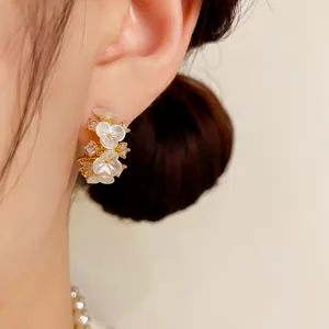 Elegante Franse bloemenoorbellen met witte parelmoer blaadjes en kristallen accenten