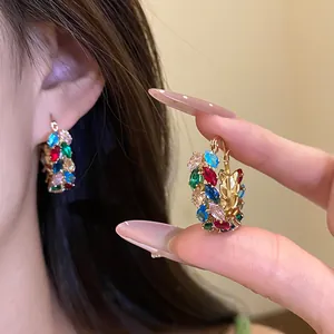 Detailed macro shot of vintage-style hoop earrings featuring colorful zircons and gold wheat ear accents