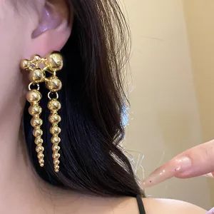 Detailed close-up showing the elegant gold beaded dangle design of vintage earrings