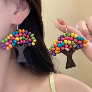 Vue détaillée de boucles d'oreilles ethniques en forme d'arbre avec perles en bois