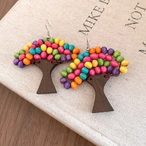 Gros plan sur des boucles d'oreilles en forme d'arbre avec des perles en bois colorées