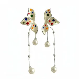 Elegant white polka dot flower tassel earrings with pearls on white background